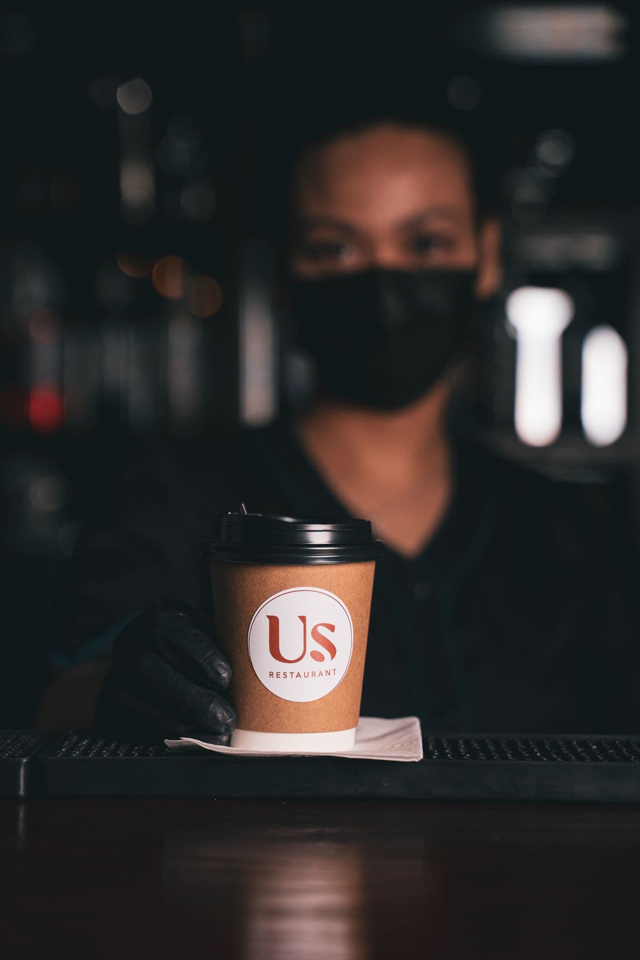 A staff member handing over a freshly made order at the counter
